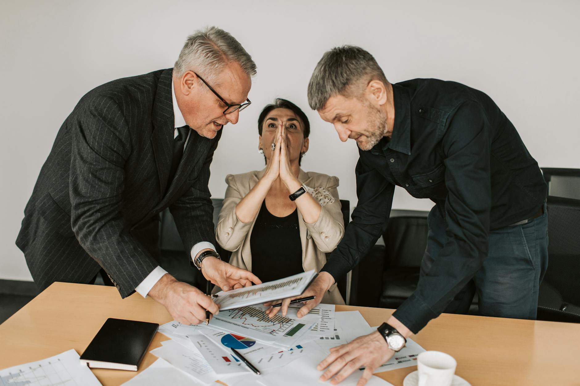 A group of diverse professionals engaged in a focused discussion in a modern office setting.