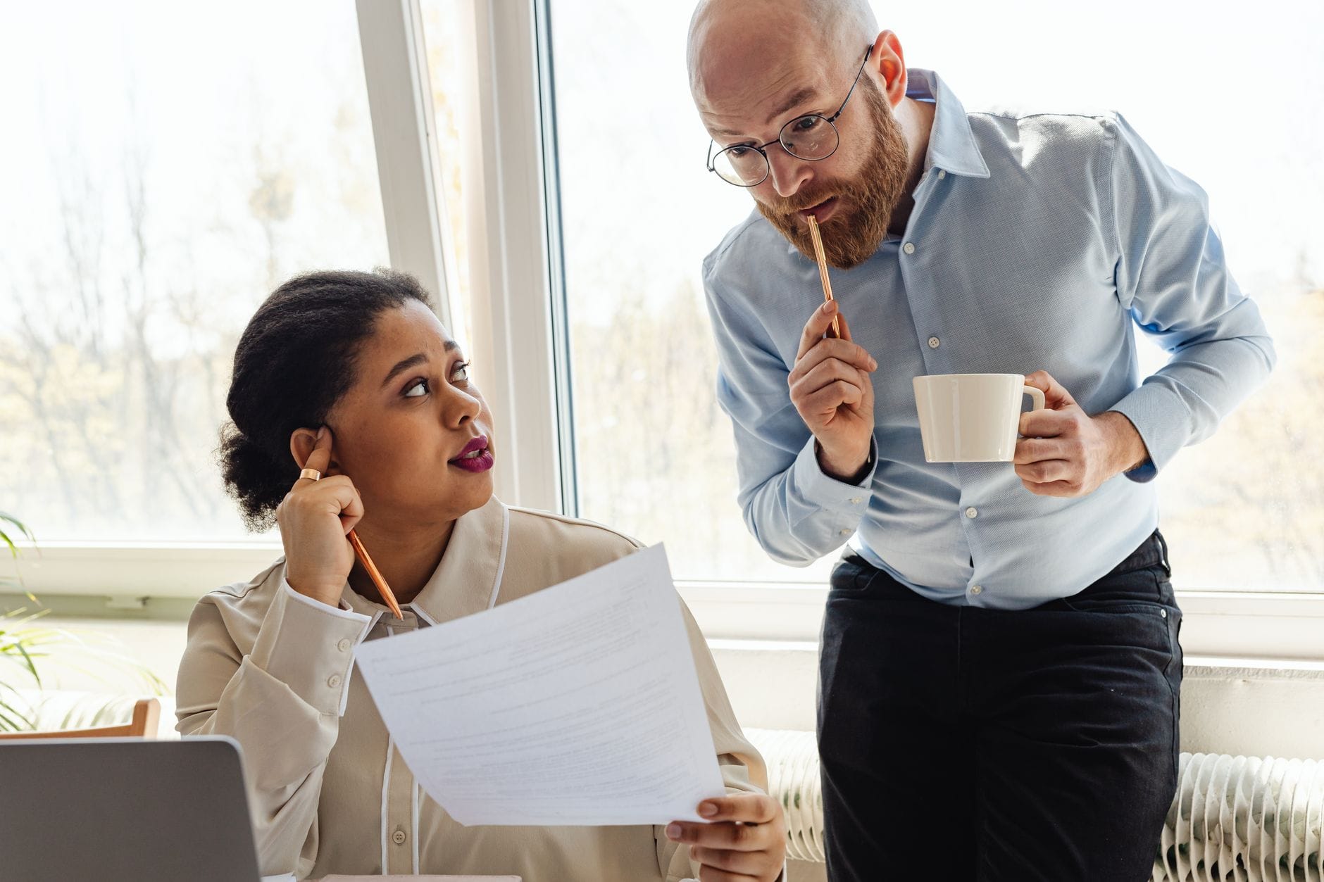 Two business colleagues reviewing documents together in a bright office. — hubspot review 2026