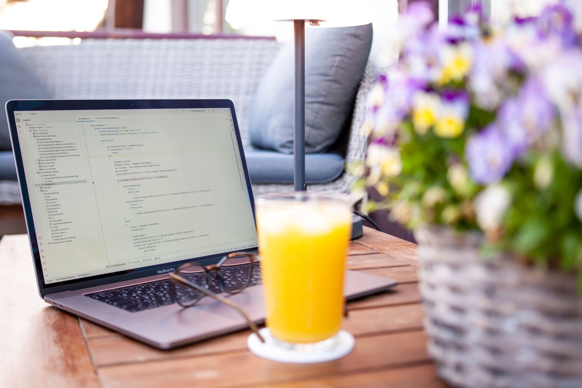Laptop with code, a glass of orange juice, and flowers create a perfect outdoor work setting. — slack mcp server mcp ser