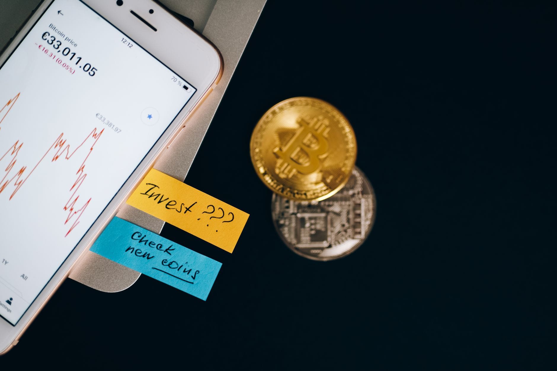 Bitcoin coins and smartphone displaying price chart with investment notes. — hubspot review 2026
