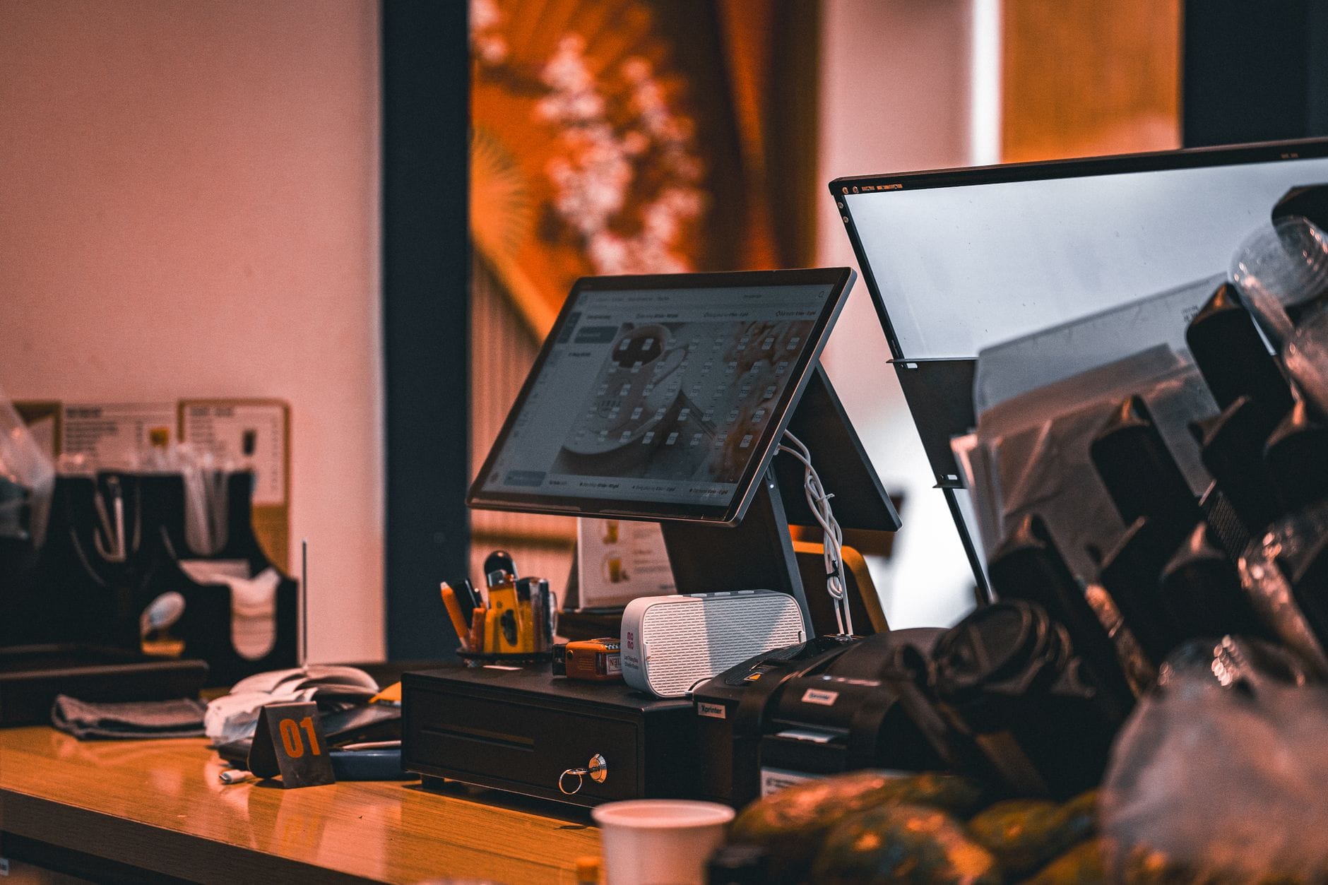 Counter with cash register and computer screen in Ho Chi Minh City cafe, offering a modern and warm ambiance. — postgres
