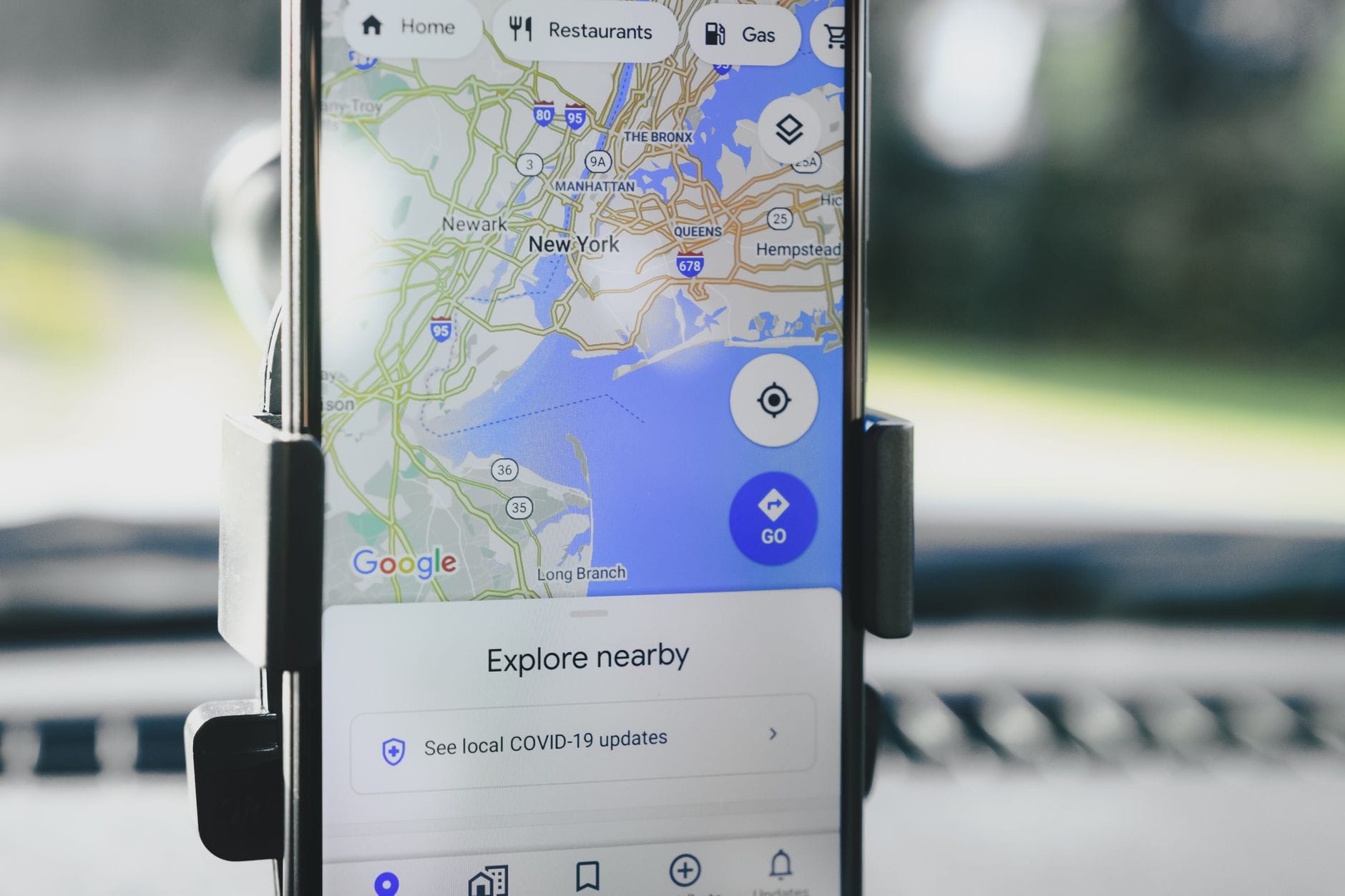 A smartphone displaying GPS map of New York City secured in a car mount during daylight. — google maps mcp server mcp se