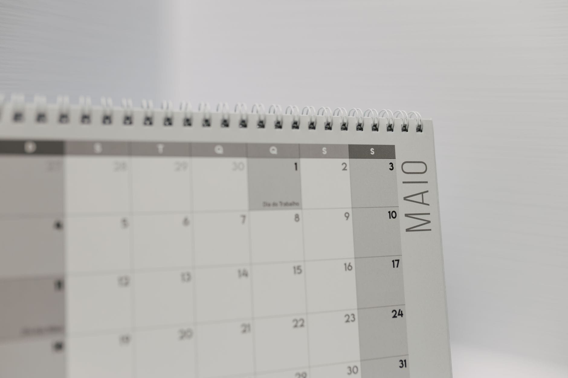 Spiral-bound calendar showing May with focus on weekdays in Portuguese. — taplio review 2026