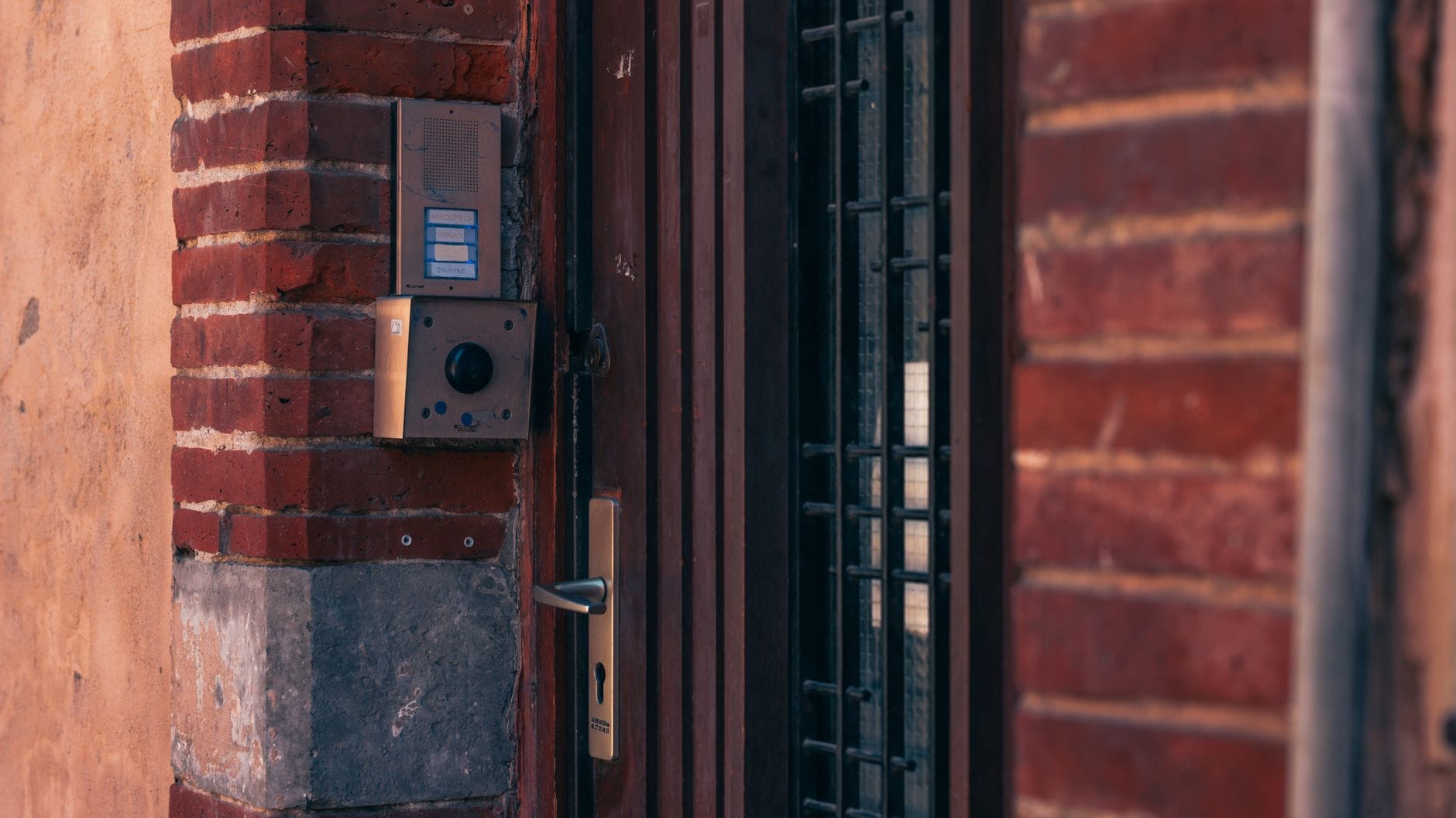 Close-up of a brick wall with a security intercom and door handles in Toulouse, France. — openai cybersecurity model sta