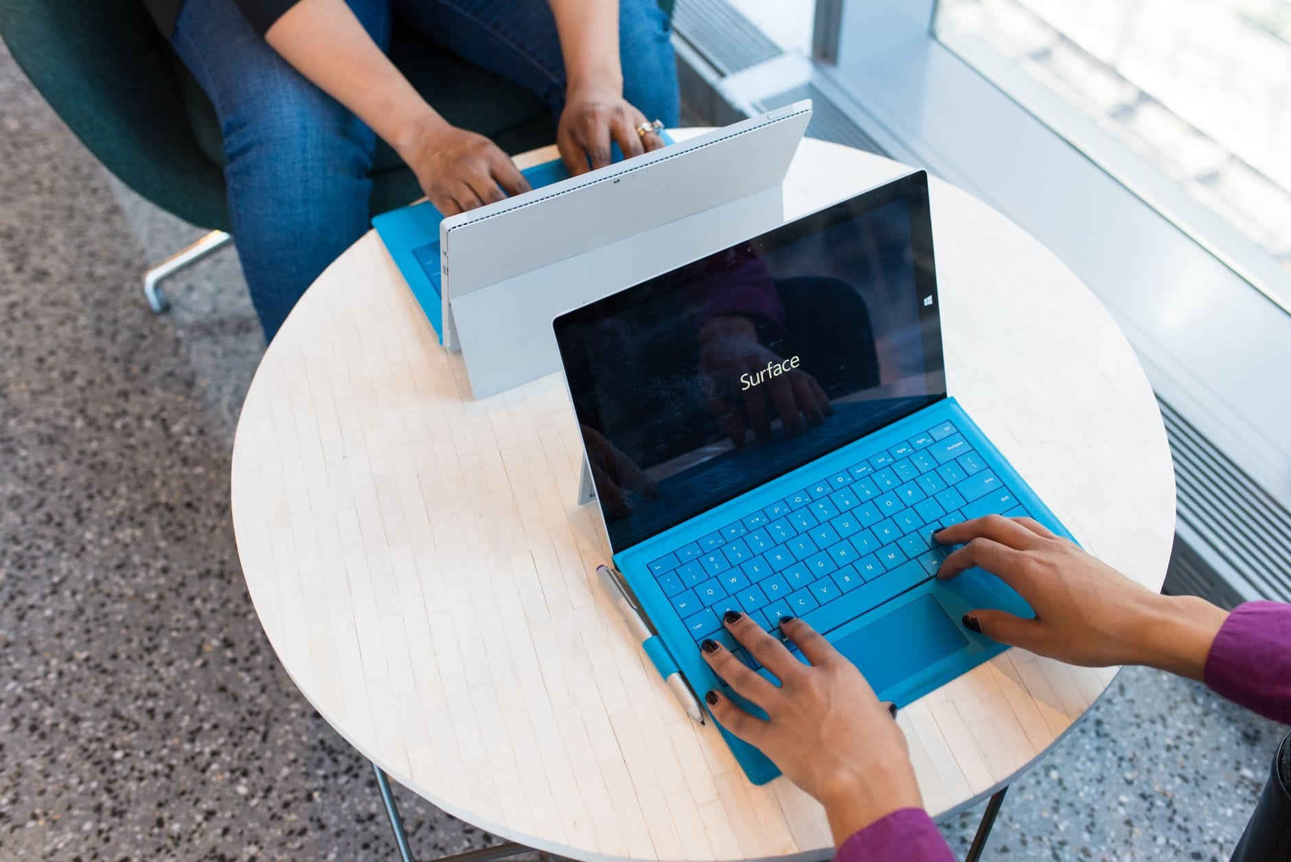 Two individuals working on laptops indoors, embodying remote work and technology. — cursor review 2026