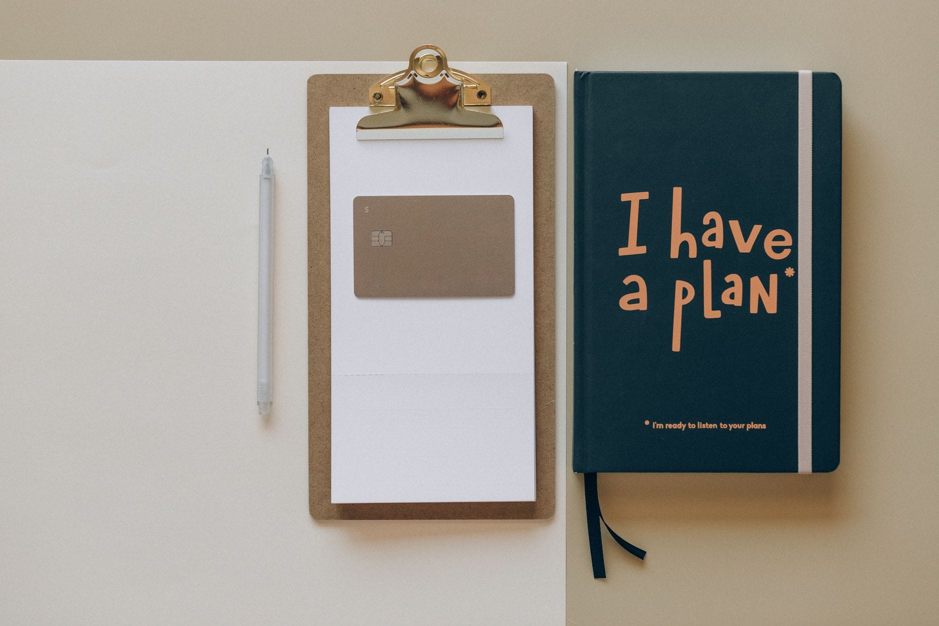 A minimalist office setup featuring a planner, clipboard, card, and pen, perfect for planning and organization. — taplio
