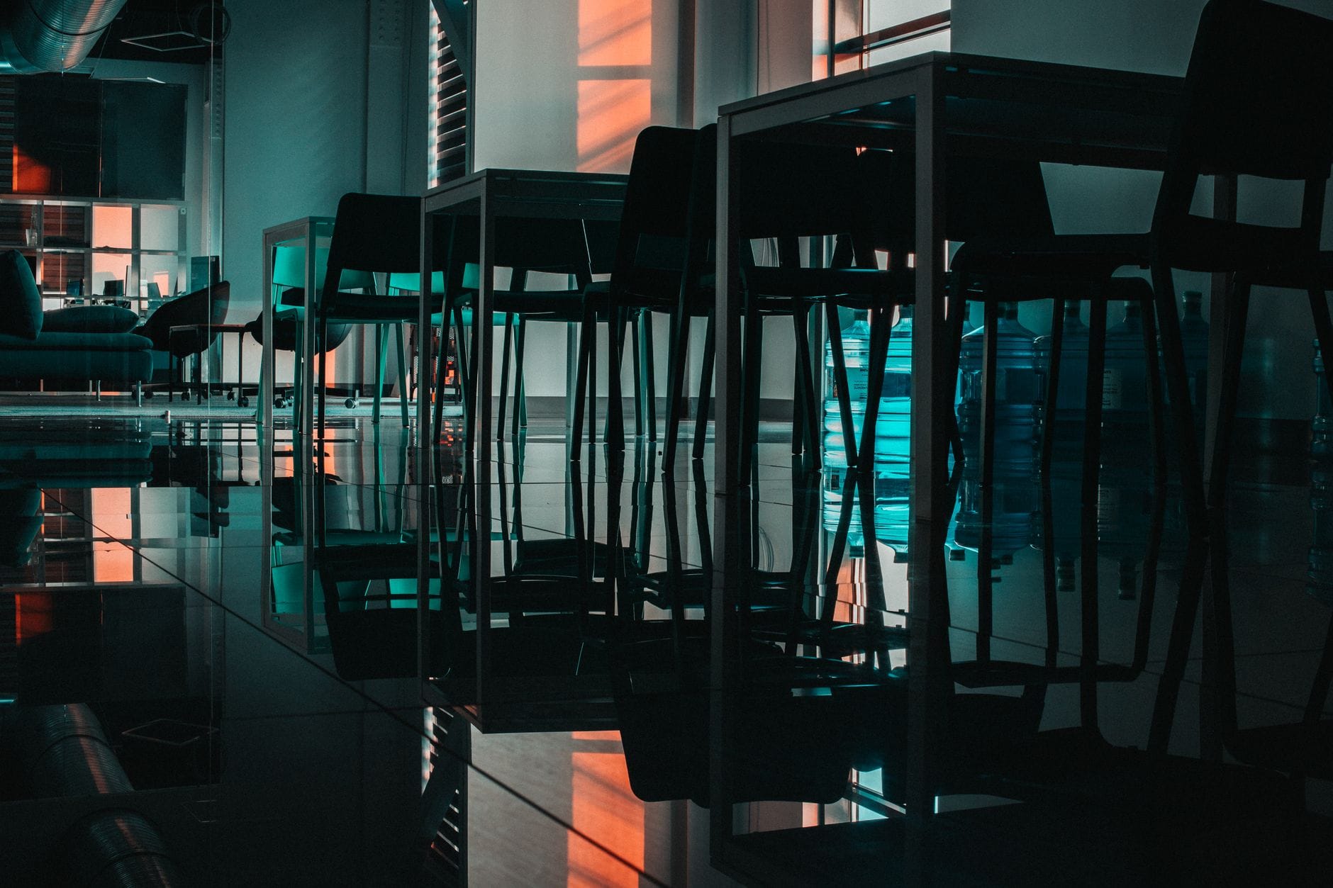 A dimly lit modern office interior with reflective flooring and empty chairs casting shadows. — sqlite mcp server mcp se