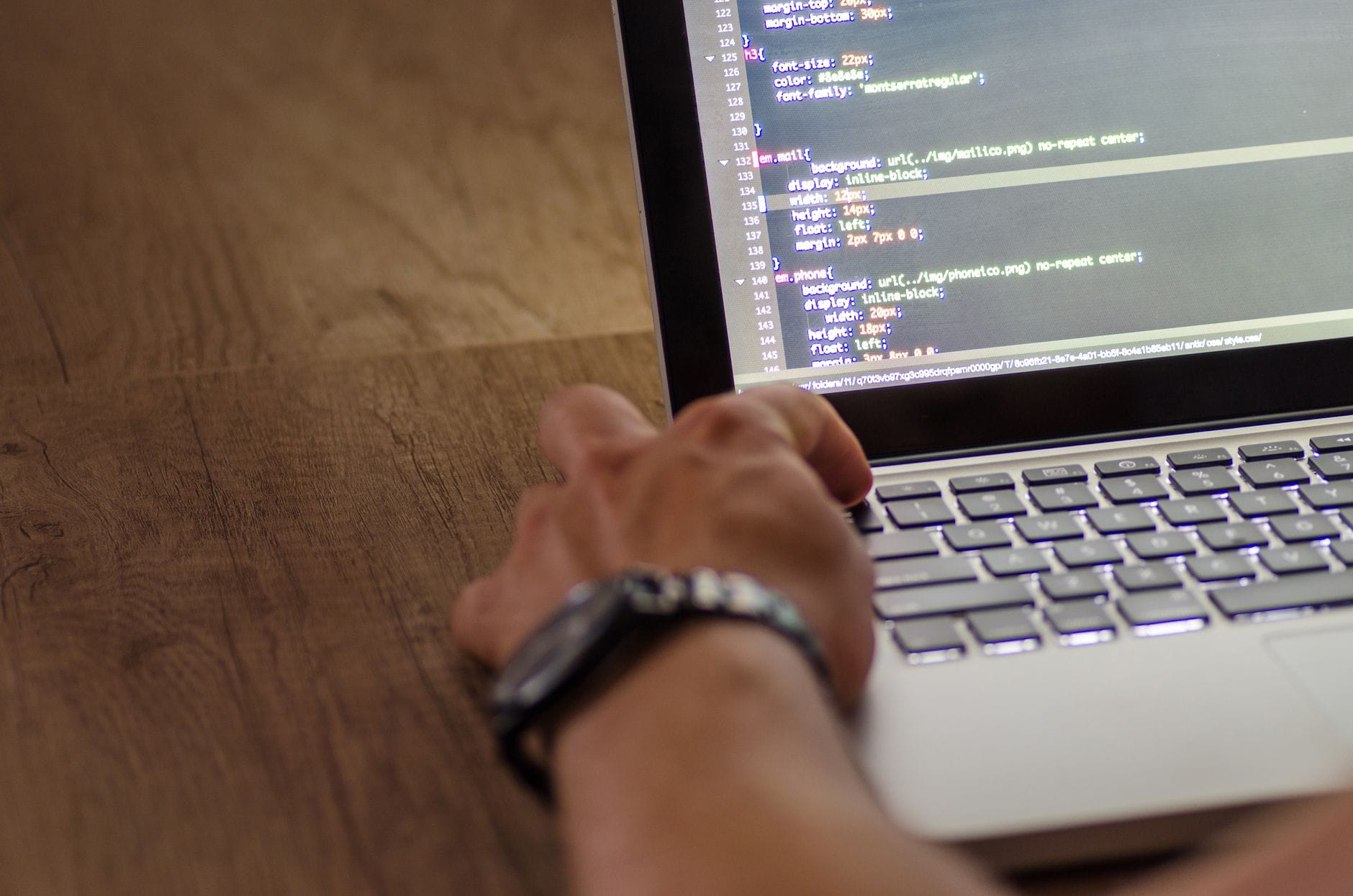 A developer's hand interacting with code on a laptop screen in a workspace setting. — sentry mcp server mcp server setup