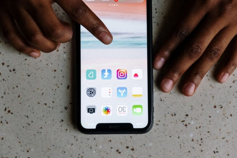 Close-up view of hands interacting with social media apps on a smartphone screen. — anthropic claude app store number on