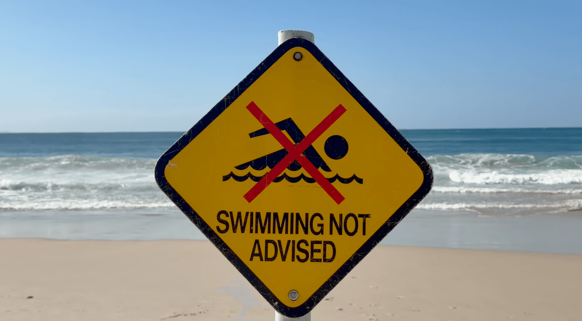 Warning sign on Byron Bay beach advising against swimming due to safety concerns. — sentry mcp server mcp server setup g