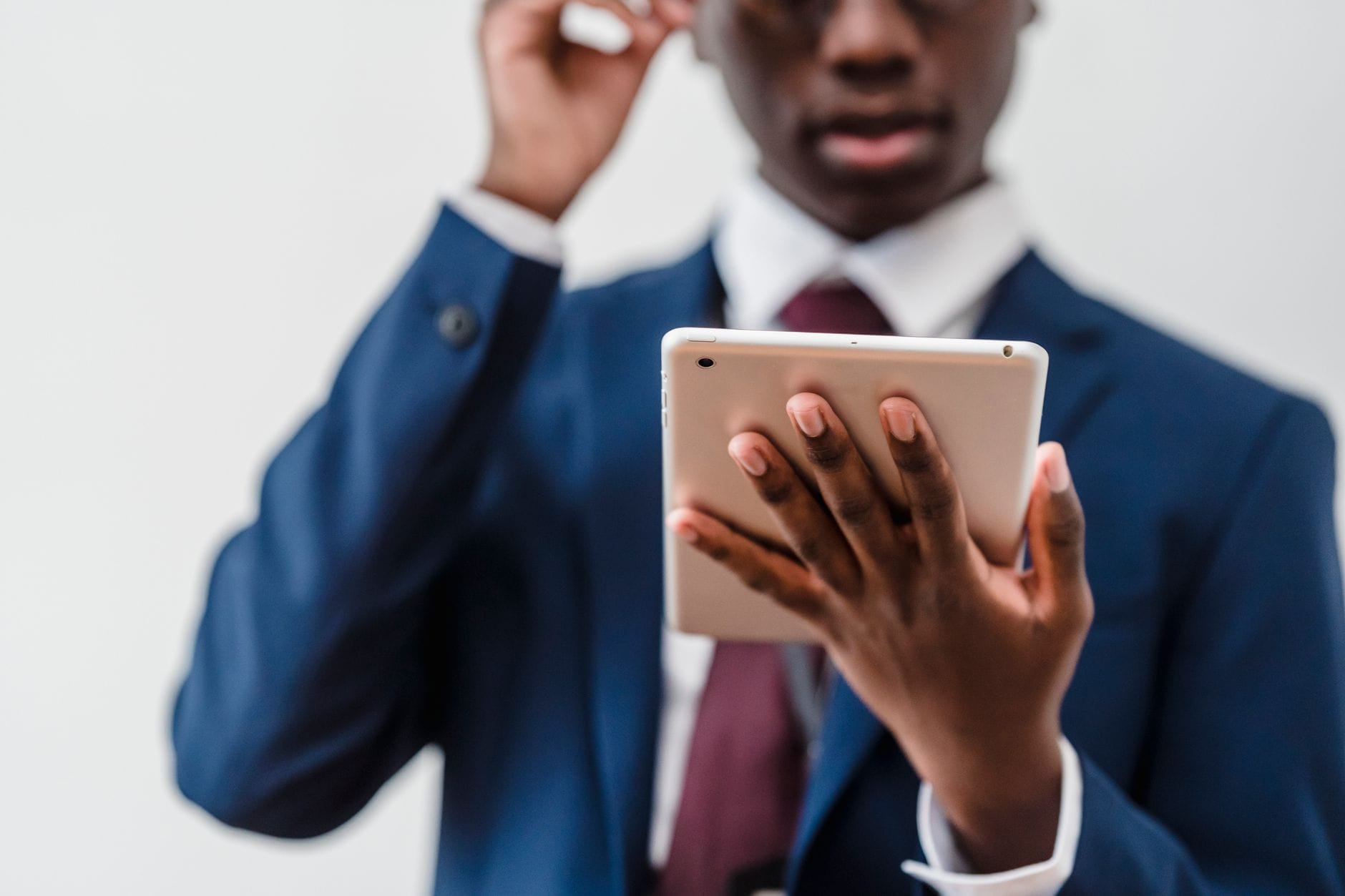 Focused businessman in a suit interacting with a tablet indoors. — github copilot review 2026